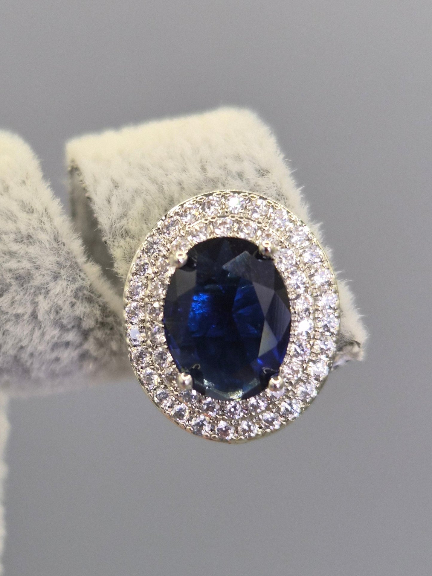 Oval Blue Center Stone Surrounded By Double Row of Round Brilliant Cut Cubic Zirconia Stud Earrings