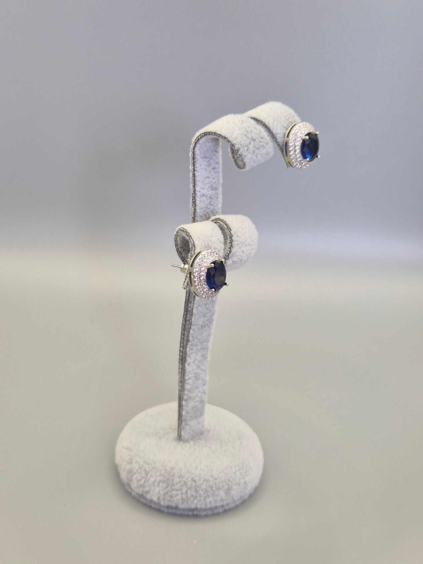 Oval Blue Center Stone Surrounded By Double Row of Round Brilliant Cut Cubic Zirconia Stud Earrings